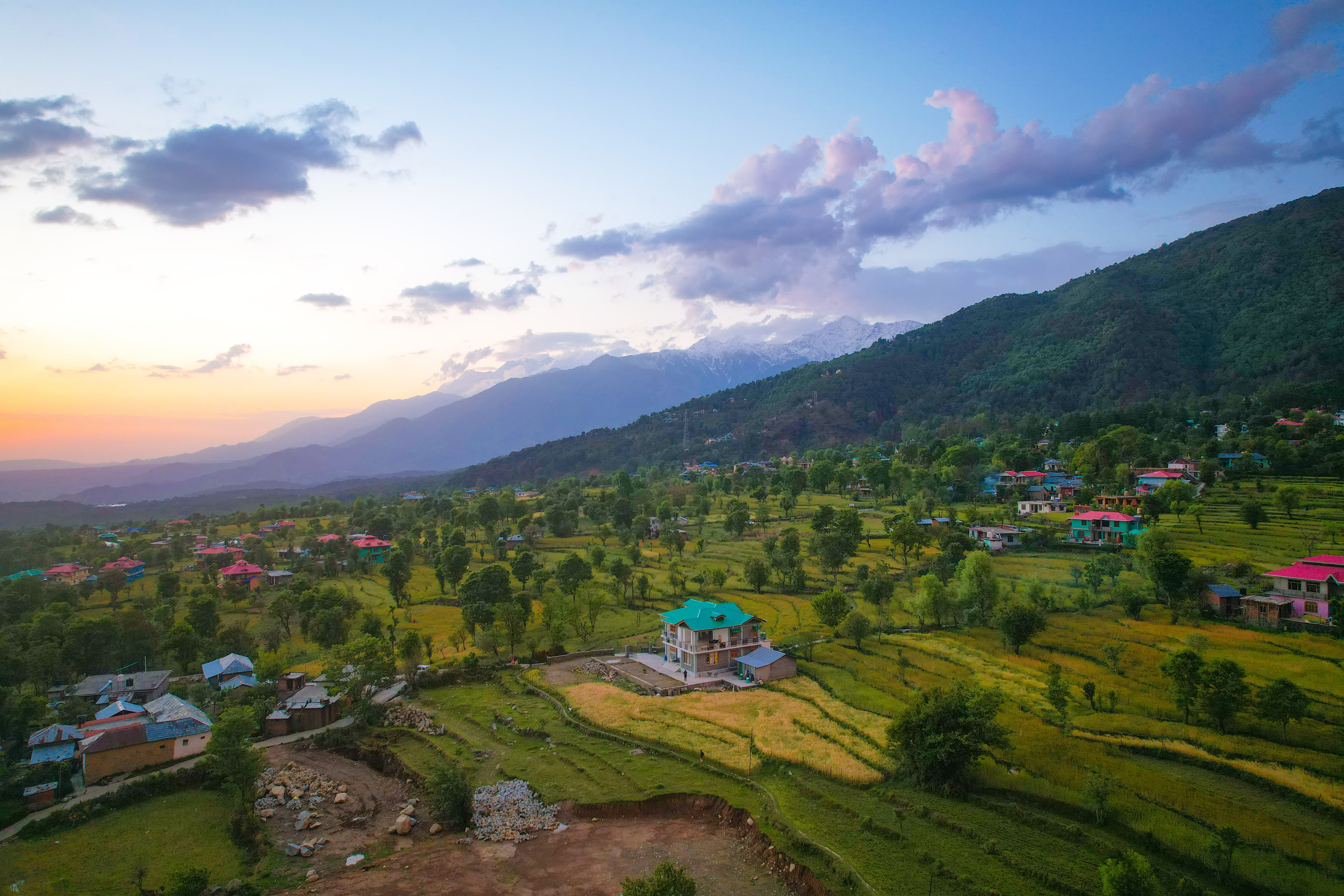 Aerial view of modern house with green roof surrounded by terraced fields