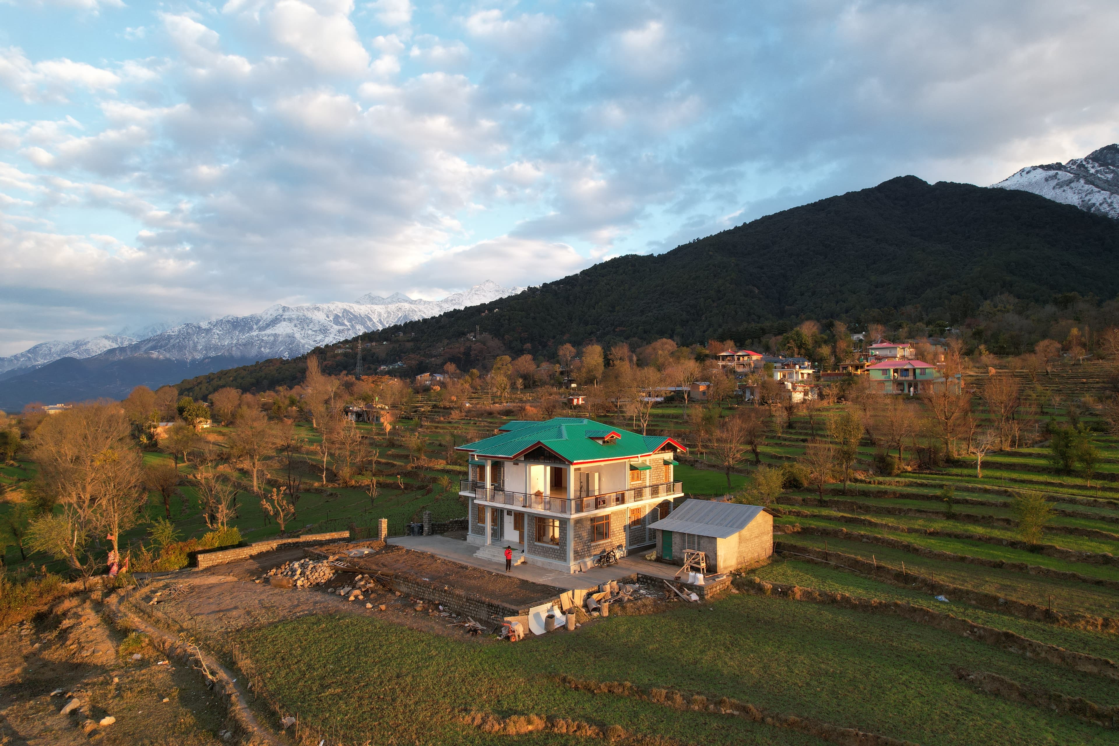 Aerial view of snow-capped mountains with terraced valley fields
