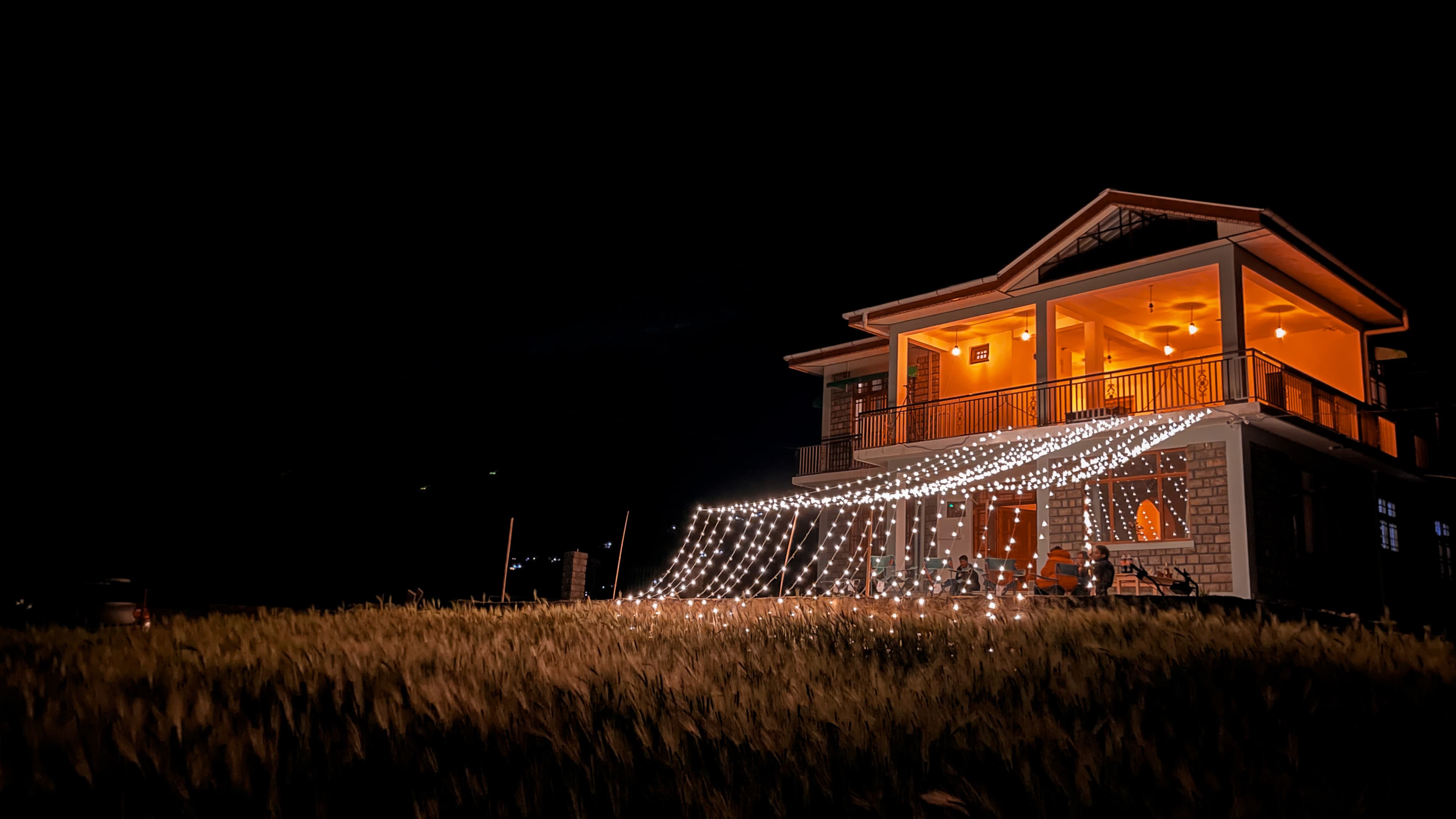 House at night with string lights over field