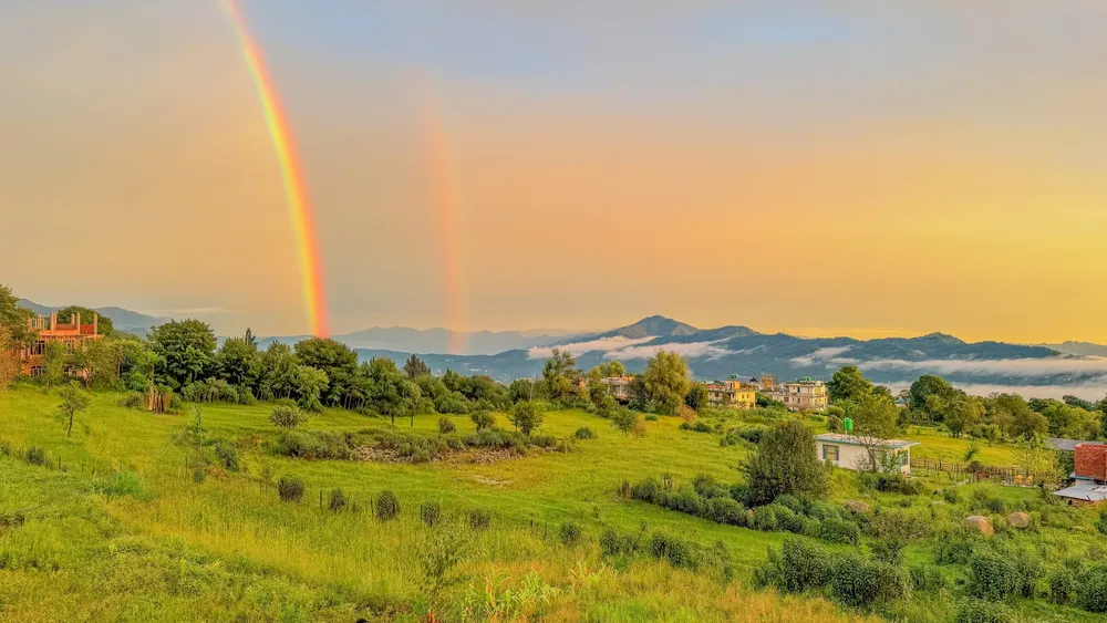 Monsoon rainbow over Bir Billing valley hidden in mist